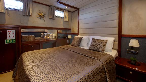 In der Gästekabine der Perdue in Fethiye sind ein Doppelbett, Holzdetails und Stauraum zu sehen.