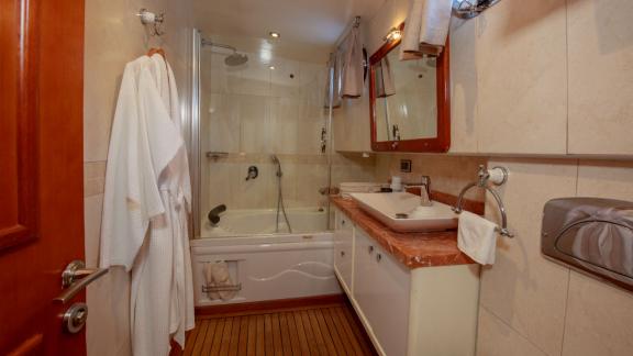 Im Gästebad der Perdue in Fethiye sind Badewanne, Waschbecken und ein großer Spiegel zu sehen.