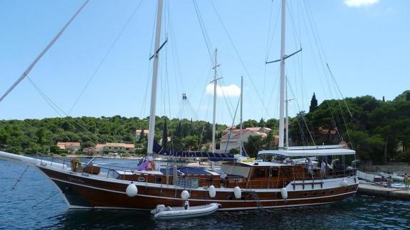 Die Gulet Perla mit sechs Kabinen liegt in Split vor Anker, umgeben von einer malerischen Küstenlandschaft und Gebäuden.