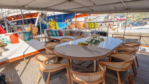 Princess Alize gulet features a spacious outdoor dining table and a comfortable lounge area on the aft deck.