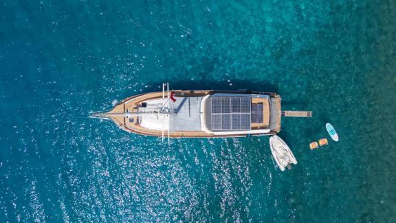 Among Fethiye yacht rental options Queen Alin is anchored in clear water top view with tender and water toys visible.
