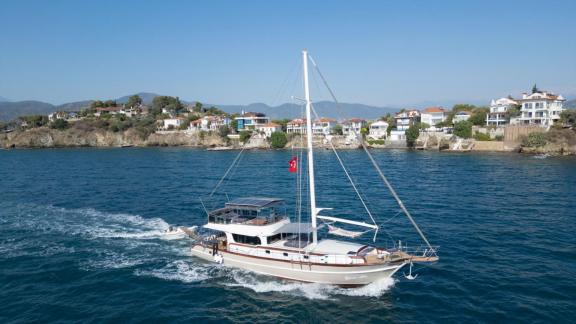 Among gulet rental options in Fethiye Queen Alin is seen cruising at sea with coastline view.