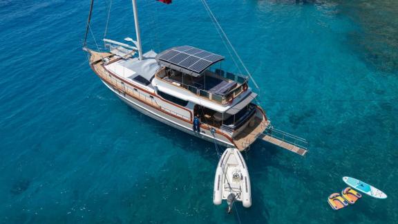 Unter den Yachtcharter Optionen in Fethiye zeigt Queen Alin Draufsicht im klaren Wasser mit Beiboot und Plattform.