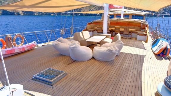 The deck of gulet Sea Angel 2 features a cozy seating area with sea views and sun loungers.