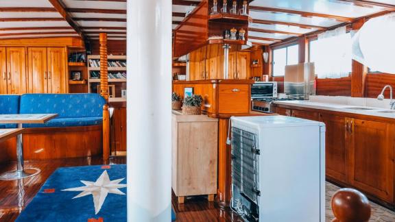 The kitchen on gulet Sea Angel 2 is fully equipped and surrounded by wooden cabinets.