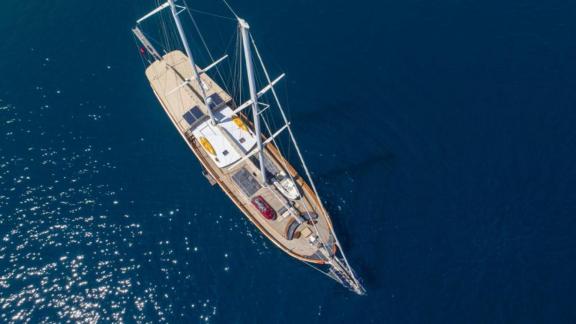 Aerial view of the gulet Sema Tuana with 6 cabins on calm, deep blue water.