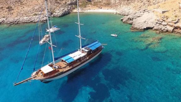 Luftaufnahme der Gulet Semercioglu, die in einer malerischen Bucht mit türkisfarbenem Wasser vor Anker liegt.