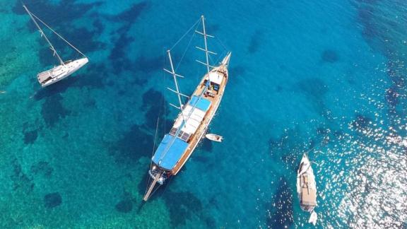 Luftaufnahme der Gulet Semercioglu, die in türkisfarbenem Wasser vor Anker liegt, umgeben von zwei weiteren Booten.