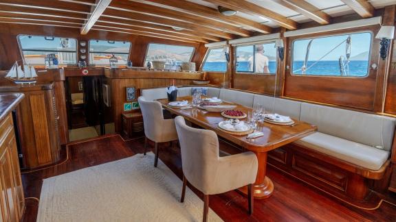 Luxurious interior of the Serenad yacht with a stylish dining table and panoramic sea views.