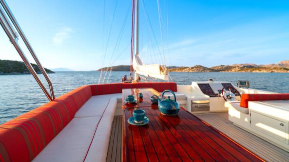 In Göcek gulet charter option Serenity 86 flybridge with seating area table and sea view offering relaxing space visible