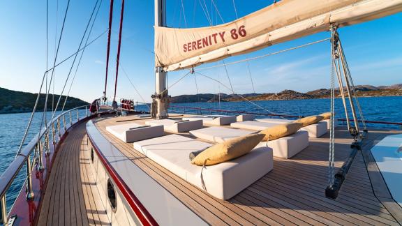 In Göcek gulet charter option Serenity 86 foredeck with large sunbeds and open sea view offering relaxing space visible.