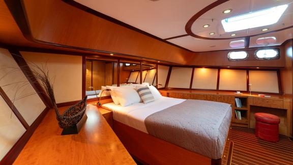 In Göcek gulet charter option Serenity 86 master cabin with large bed wooden details and spacious interior visible.