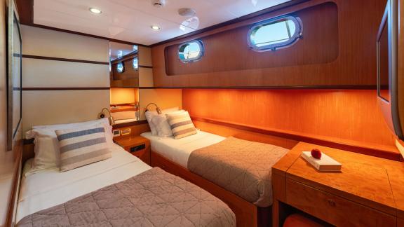 In Göcek gulet charter option Serenity 86 cabin with two single beds workspace and modern interior offering comfort visi