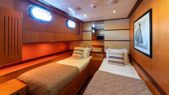 In Göcek gulet charter option Serenity 86 cabin with two single beds lighting and storage space offering comfortable use