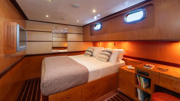 In Göcek gulet charter option Serenity 86 cabin with double bed storage space and cozy interior visible.