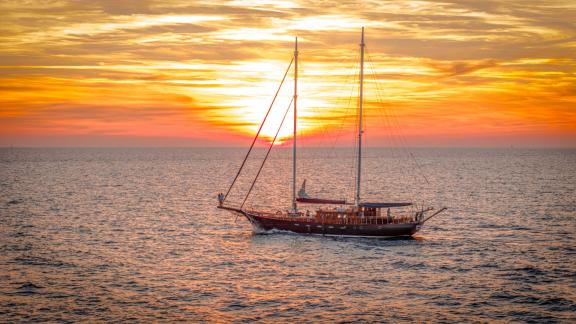 Die Gulet Smart Spirit segelt vor einem spektakulären Sonnenuntergang auf dem Meer.