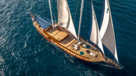 Aerial view of the gulet Smart Spirit gliding across the open sea under full sail.