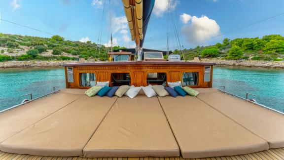 Spacious sun loungers on the deck of the gulet Smart Spirit, which is anchored in an idyllic bay.