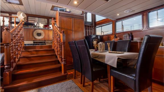 Elegant dining area with wooden table and leather armchairs in a stylish gulet.