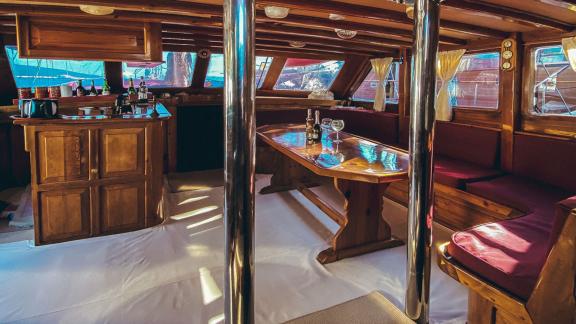 Warm lounge with wooden furnishings and comfortable seating. Perfect for social evenings onboard.