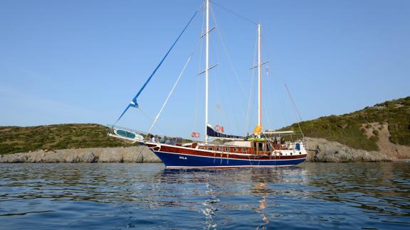 Die Gulet Sıla ankert friedlich vor der malerischen Küste von Bodrum, ideal für entspannte Segeltörns.