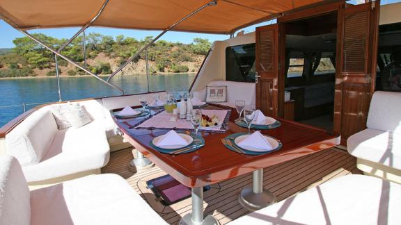 In Bodrum Gulet chartern Option Tango Charlie Achterdeck mit gedecktem Tisch und Sitzbereich sichtbar.