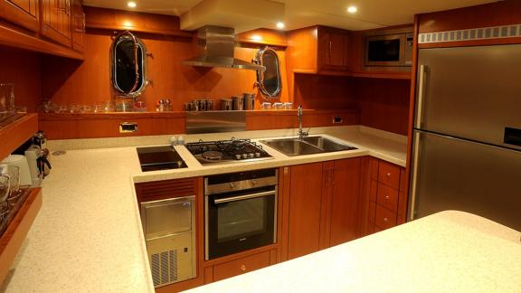 In Bodrum Gulet chartern Option Tango Charlie Küche mit Herd Ofen Kühlschrank und Arbeitsfläche sichtbar.