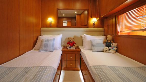 In Bodrum gulet charter option Tango Charlie cabin with two single beds nightstand and lighting visible.