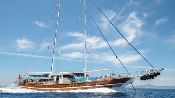 The gulet Tarkan 5 sails at full speed off the coast of Fethiye, with majestic masts and clear blue skies.