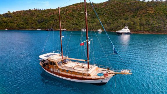 Charming Gulet Thalasa sailing in calm Turkish waters with scenic coastal views.