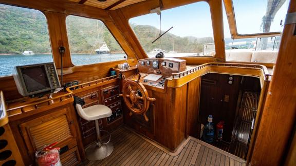 Interior view of the helm area of Gulet Thalasa with wooden fittings and navigation equipment.