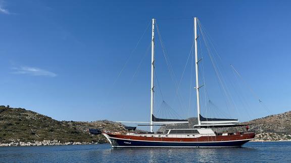 In Marmaris Gulet chartern Option Tosca vor Anker in ruhiger Bucht mit großem Deck und komfortabler Nutzung sichtbar.