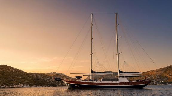 In Marmaris Gulet chartern Option Tosca bei Sonnenuntergang vor Anker mit großem Deck und entspannter Atmosphäre sichtba