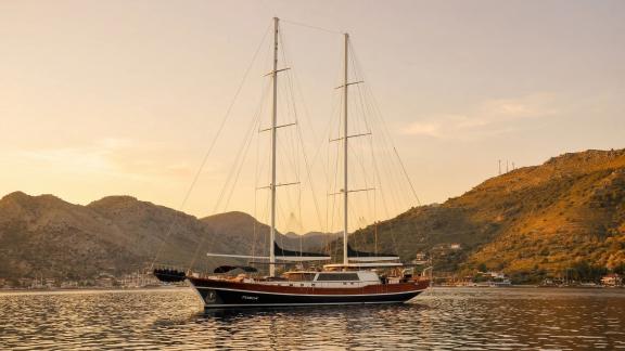 In Marmaris gulet charter option Tosca anchored at sunset in calm bay with peaceful atmosphere and comfortable onboard e