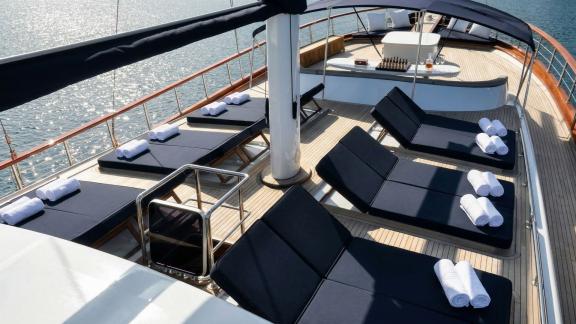 In Marmaris gulet charter option Tosca foredeck with sun loungers and sea view offering calm and comfortable relaxation.
