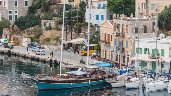 Gulet Valerie docked in the harbor beside historic buildings.