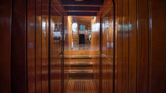 The interior corridor of Gulet Valerie is designed with wooden wall paneling.