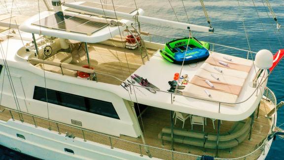 Deck of the gulet Vega with deckchairs, water sports equipment and Turkish flag.