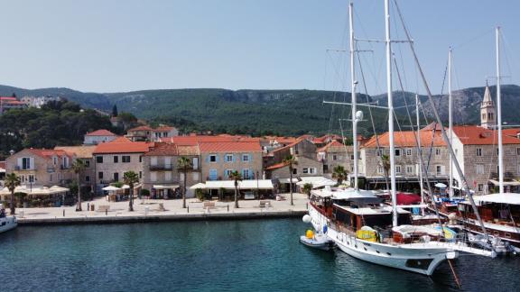 Der luxuriöse Gulet Vivere liegt im belebten Hafen von Dubrovnik, Kroatien, vor Anker. Im Hintergrund sind charmante Geb