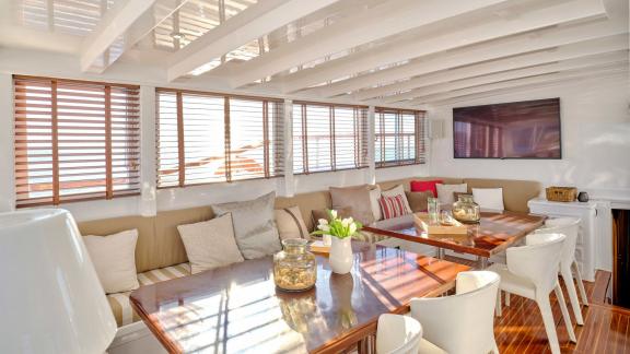 The saloon of White Pearl gulet in Athens features spacious seating and a polished dining table.