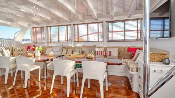 The saloon of White Pearl gulet in Athens features spacious seating and a polished dining table.