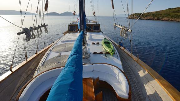 The spacious deck of Gulet Xenos 2 in Bodrum featuring comfortable seating and a kayak.