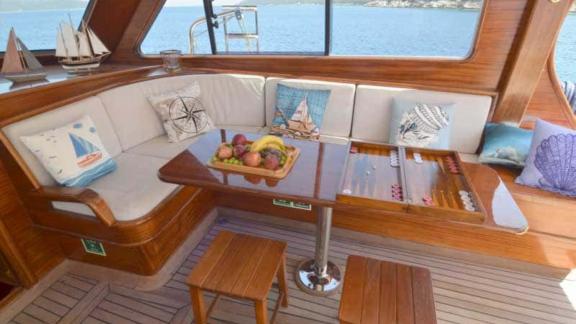 Yachtcharter in der Türkei. Entspannen Sie sich in der gemütlichen Lounge mit Obst, Backgammon und herrlichem Meerblick.