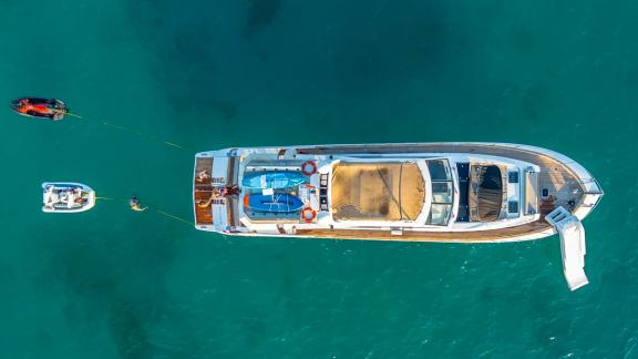 Parodia II yacht is anchored off Mallorca with sea toys and a slide visible from above.