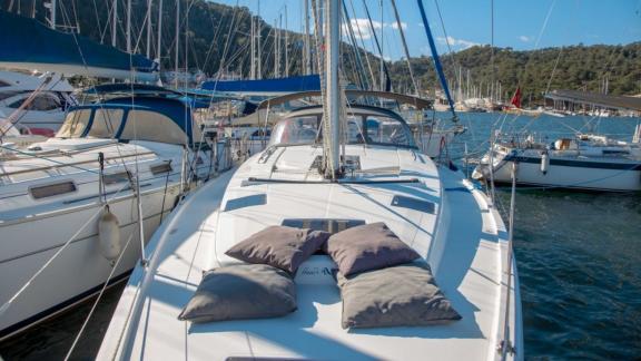 The foredeck of the Beau Gosse sailing yacht features a sunbathing area with comfortable cushions.