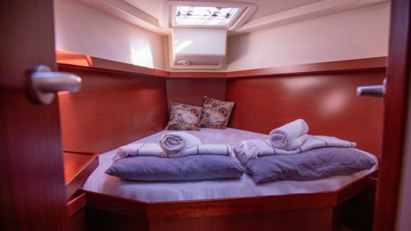 The double cabin on the Beau Gosse sailing yacht features a comfortable bed and pillows.