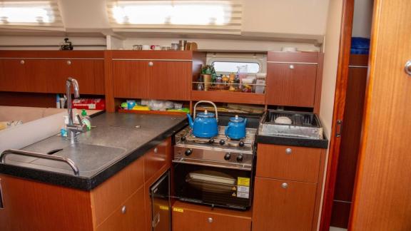 The kitchen on the Beau Gosse sailing yacht features a modern countertop and stove with full equipment.