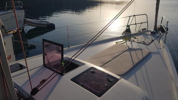 Foredeck of sailing yacht Baxter, anchored in calm waters at sunset.