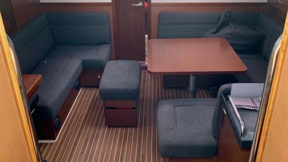 The salon of sailing yacht Baxter offers a spacious seating area and a comfortable atmosphere with dark upholstery.