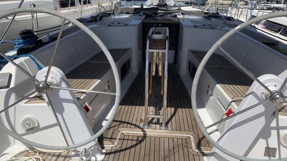 The cockpit of the Aldebaran sailing yacht with twin wheels and wooden details offers a modern look.